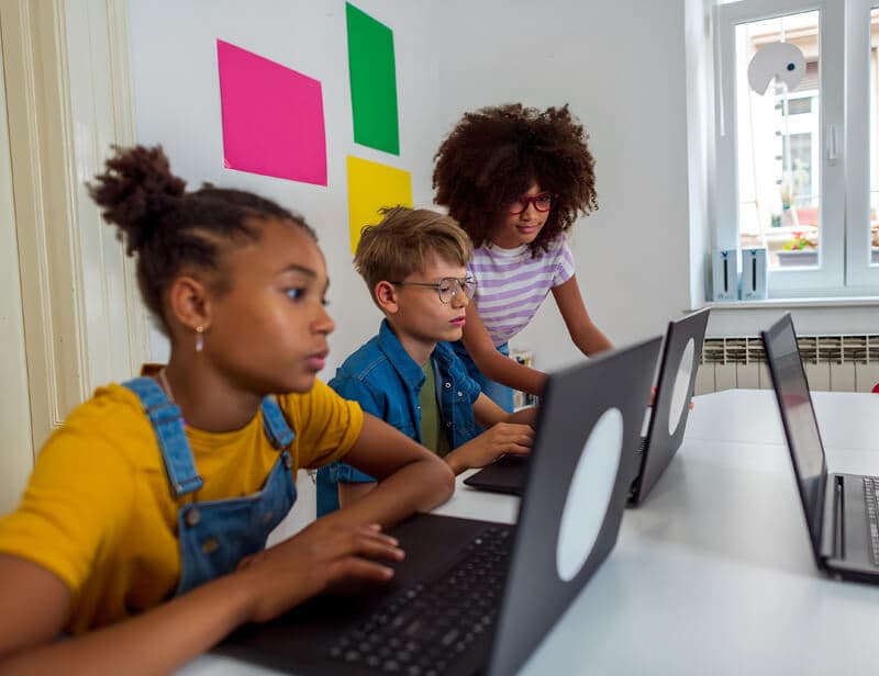 Children learning together on laptops during a live online class