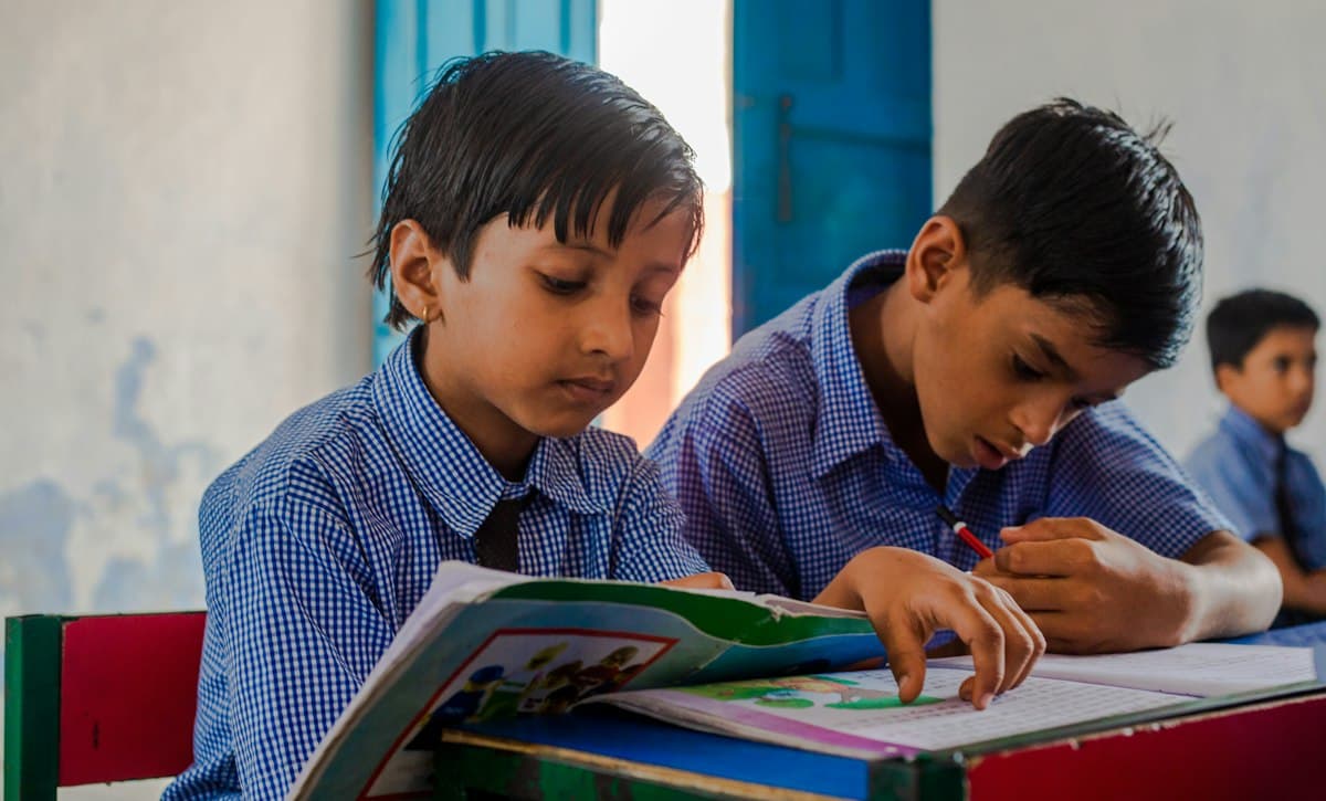 Two schoolboys studying together from a book